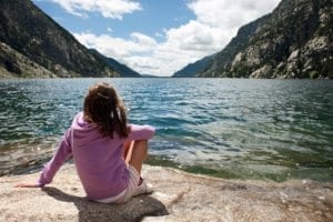 Girl sits by lake polluted by fluoride