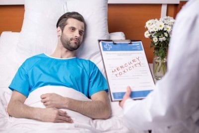 Sick patient in bed with doctor discussing reactions and side effects due to mercury toxicity